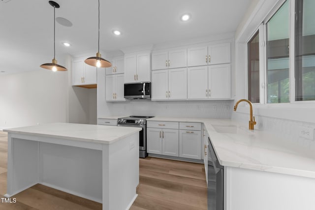 710 W N St Unit 101, Raleigh, NC 27603 - kitchen featuring stainless steel appliances, a sink, light wood finished floors, decorative backsplash, and recessed lighting