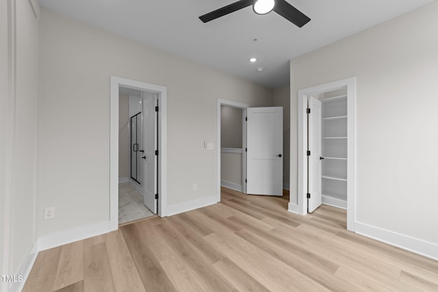 710 W N St Unit 101, Raleigh, NC 27603 - unfurnished bedroom with light wood-style flooring, a walk in closet, and baseboards