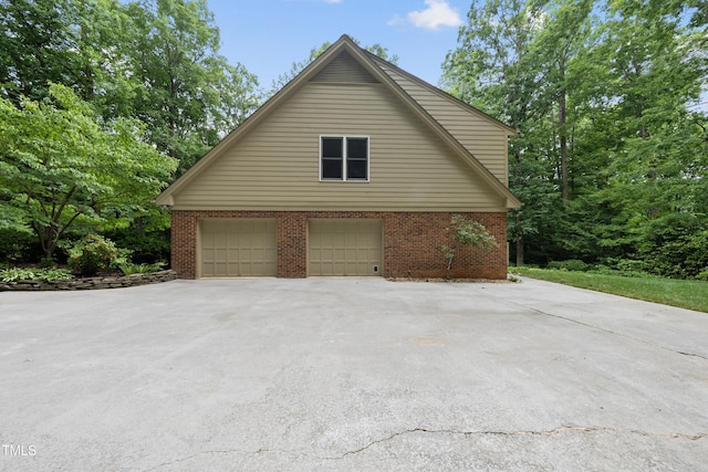 2300 Valley Forge Dr, Raleigh, NC 27615 - view of side of home with driveway, an attached garage, and brick siding