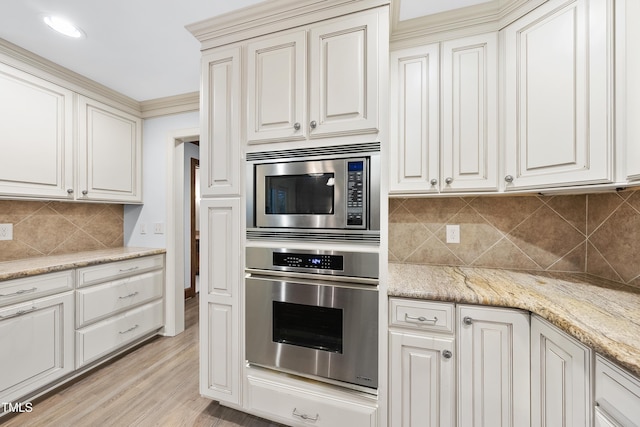 2300 Valley Forge Dr, Raleigh, NC 27615 - kitchen with appliances with stainless steel finishes, decorative backsplash, light wood-style floors, light stone countertops, and white cabinetry
