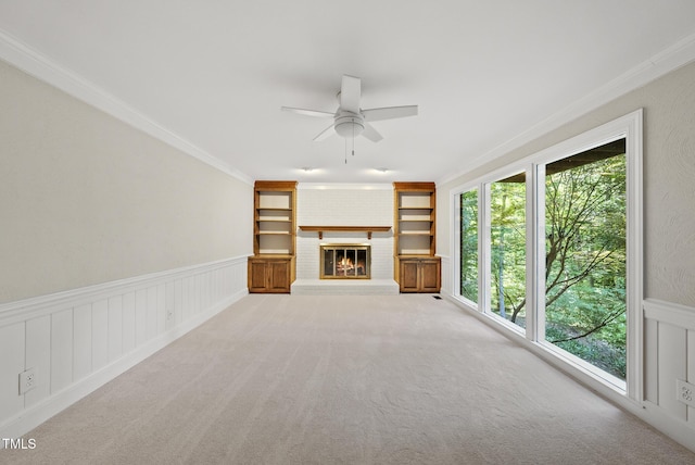 2300 Valley Forge Dr, Raleigh, NC 27615 - unfurnished living room with a ceiling fan, ornamental molding, built in shelves, a brick fireplace, and a wainscoted wall