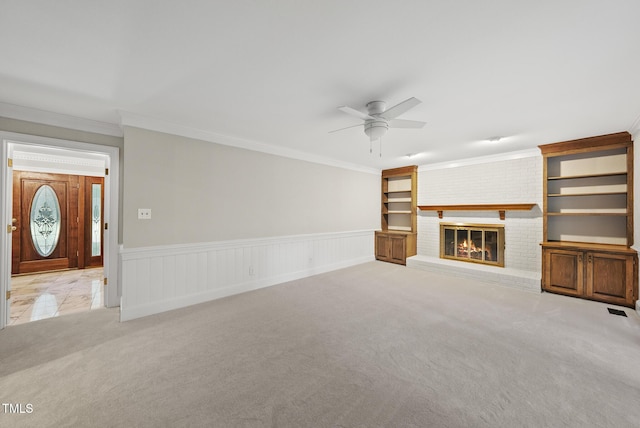 2300 Valley Forge Dr, Raleigh, NC 27615 - unfurnished living room featuring light carpet, a ceiling fan, a fireplace, ornamental molding, and wainscoting