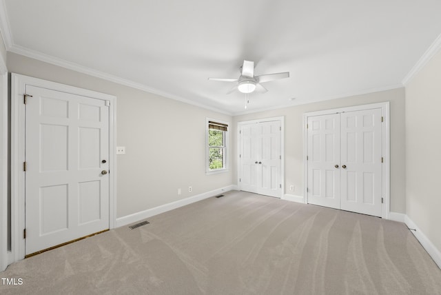 2300 Valley Forge Dr, Raleigh, NC 27615 - unfurnished bedroom featuring two closets, ornamental molding, carpet flooring, and a ceiling fan