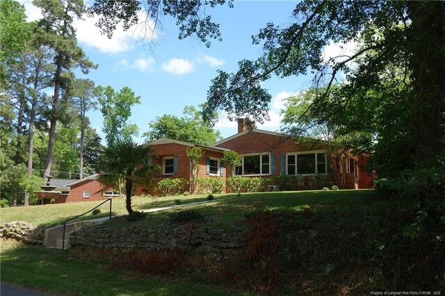 706 Riverside Dr, Lumberton, NC 28358 - ranch-style house with a front yard and a chimney