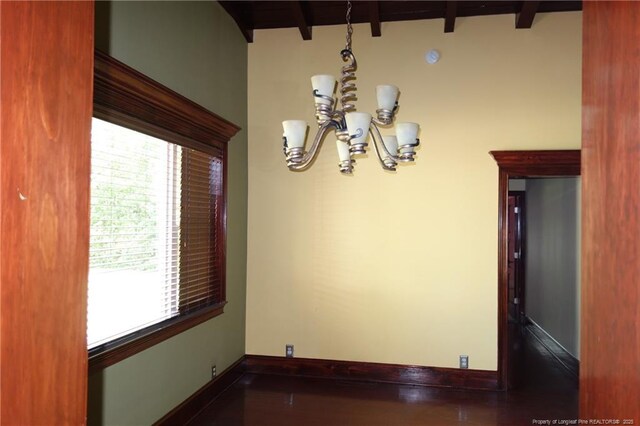 706 Riverside Dr, Lumberton, NC 28358 - empty room featuring a chandelier, beamed ceiling, and baseboards
