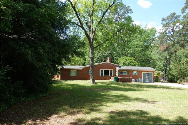 706 Riverside Dr, Lumberton, NC 28358 - back of property with a chimney, a yard, and brick siding