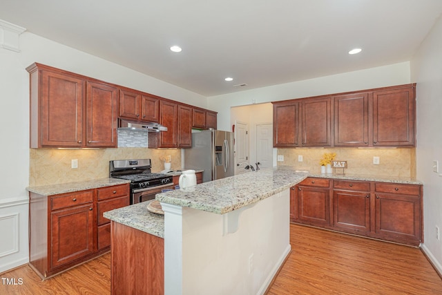 233 Hammond Wood Pl, Morrisville, NC 27560 - kitchen featuring appliances with stainless steel finishes, light wood-type flooring, a center island, light stone countertops, and recessed lighting