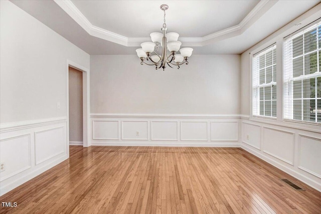 1420 Lagerfeld Way, Wake Forest, NC 27587 - unfurnished dining area with a chandelier, a raised ceiling, light wood-type flooring, a decorative wall, and ornamental molding