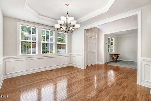 1420 Lagerfeld Way, Wake Forest, NC 27587 - unfurnished dining area with a chandelier, crown molding, light wood-style flooring, a wainscoted wall, and a decorative wall