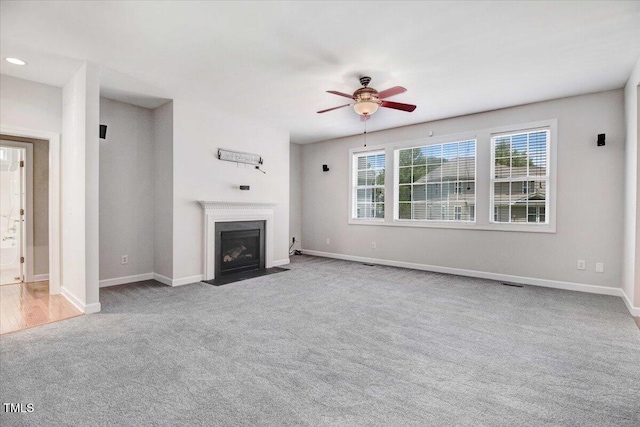 1420 Lagerfeld Way, Wake Forest, NC 27587 - unfurnished living room with carpet flooring, a fireplace with flush hearth, a ceiling fan, and baseboards