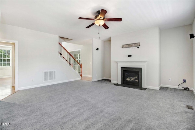 1420 Lagerfeld Way, Wake Forest, NC 27587 - unfurnished living room featuring a ceiling fan, carpet floors, stairs, a fireplace with flush hearth, and baseboards