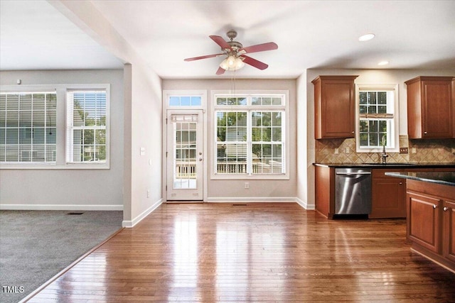 1420 Lagerfeld Way, Wake Forest, NC 27587 - kitchen with stainless steel dishwasher, a sink, hardwood / wood-style flooring, baseboards, and dark countertops