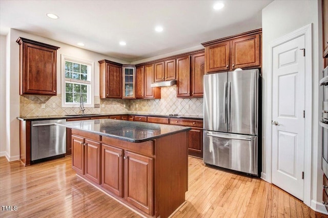 1420 Lagerfeld Way, Wake Forest, NC 27587 - kitchen with stainless steel appliances, a sink, light wood finished floors, dark stone countertops, and a kitchen island