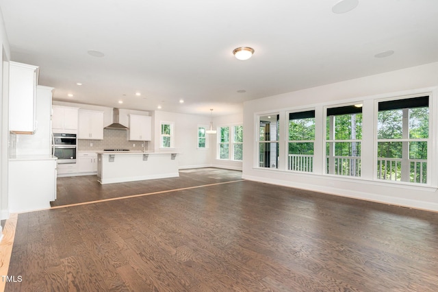 66 Sweet Meadow Ln, Pittsboro, NC 27312 - unfurnished living room with dark wood-type flooring, baseboards, recessed lighting, and a sink