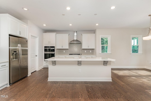 66 Sweet Meadow Ln, Pittsboro, NC 27312 - kitchen with stainless steel appliances, wall chimney exhaust hood, a center island with sink, light countertops, and dark wood-type flooring