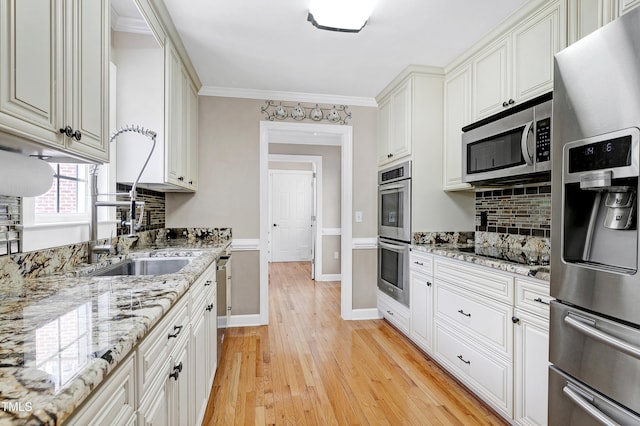2709 Les Paul Ln, Apex, NC 27539 - kitchen with appliances with stainless steel finishes, decorative backsplash, light wood-type flooring, white cabinets, and light stone counters