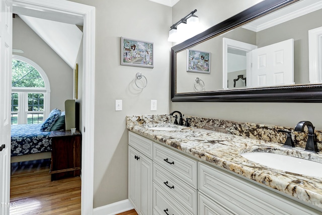 2709 Les Paul Ln, Apex, NC 27539 - bathroom featuring double vanity, ornamental molding, connected bathroom, wood finished floors, and baseboards