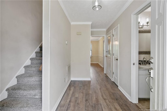 994 Eastman Rd, Fayetteville, NC 28314 - corridor featuring wood finished floors, stairway, ornamental molding, a sink, and baseboards