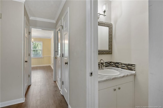 994 Eastman Rd, Fayetteville, NC 28314 - bathroom with crown molding, vanity, baseboards, and wood-type flooring