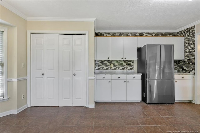 994 Eastman Rd, Fayetteville, NC 28314 - kitchen with freestanding refrigerator, light countertops, crown molding, backsplash, and white cabinets