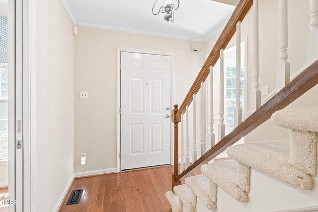 2107 Somers Ave, Burlington, NC 27215 - foyer entrance with stairs, wood finished floors, healthy amount of natural light, crown molding, and baseboards