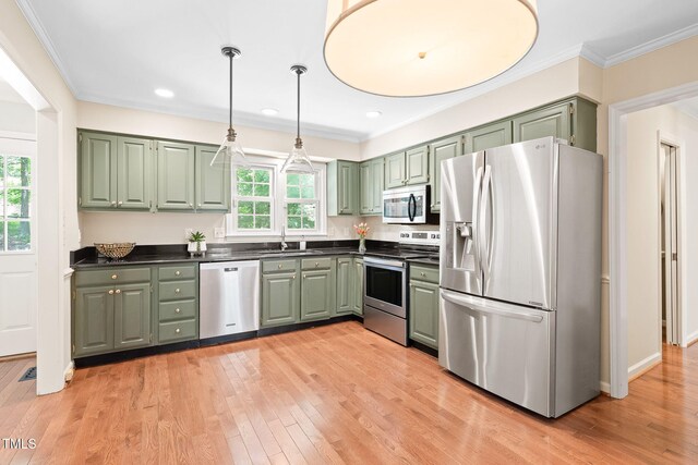 2107 Somers Ave, Burlington, NC 27215 - kitchen with appliances with stainless steel finishes, green cabinetry, a sink, dark countertops, and ornamental molding