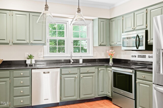 2107 Somers Ave, Burlington, NC 27215 - kitchen featuring appliances with stainless steel finishes, a sink, green cabinetry, ornamental molding, and dark countertops
