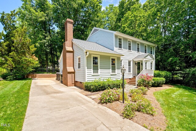 2107 Somers Ave, Burlington, NC 27215 - colonial inspired home featuring a chimney, roof with shingles, and driveway