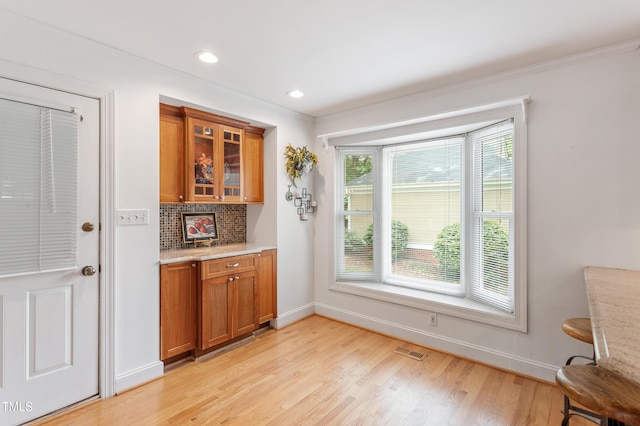 108 Ripplewater Ln, Cary, NC 27518 - bar area featuring light wood-style floors, baseboards, tasteful backsplash, ornamental molding, and recessed lighting