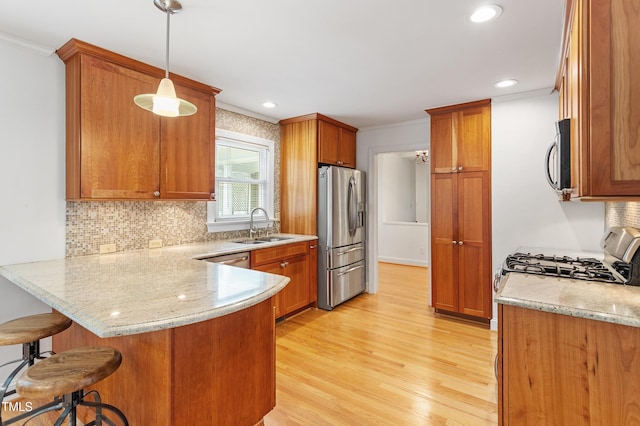 108 Ripplewater Ln, Cary, NC 27518 - kitchen with appliances with stainless steel finishes, a peninsula, a sink, brown cabinetry, and ornamental molding
