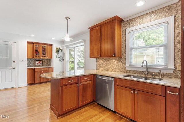 108 Ripplewater Ln, Cary, NC 27518 - kitchen with stainless steel dishwasher, a peninsula, a sink, brown cabinets, and tasteful backsplash