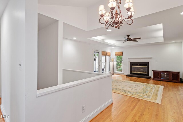 108 Ripplewater Ln, Cary, NC 27518 - unfurnished living room with wood finished floors, a ceiling fan, a raised ceiling, recessed lighting, and a chandelier