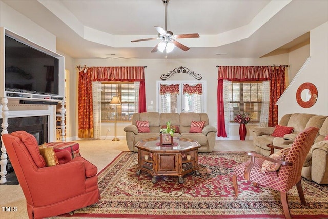 46 Spring Haven Ln, Willow Springs, NC 27592 - living room featuring a tray ceiling, ceiling fan, carpet, a glass covered fireplace, and baseboards
