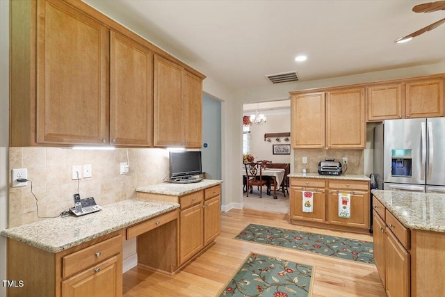 46 Spring Haven Ln, Willow Springs, NC 27592 - kitchen featuring stainless steel fridge, light wood-style flooring, tasteful backsplash, light stone countertops, and a chandelier