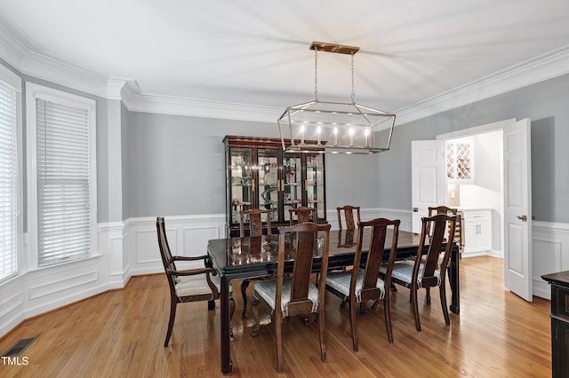 225 Midenhall Way, Cary, NC 27513 - dining area featuring a decorative wall, light wood-type flooring, ornamental molding, wainscoting, and a chandelier