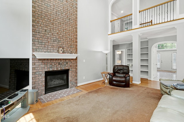 225 Midenhall Way, Cary, NC 27513 - living area featuring a brick fireplace, a high ceiling, wood finished floors, built in features, and baseboards