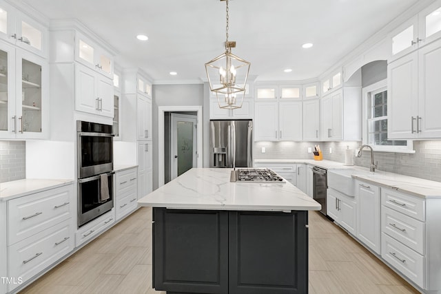 225 Midenhall Way, Cary, NC 27513 - kitchen with stainless steel appliances, a sink, white cabinetry, tasteful backsplash, and a center island
