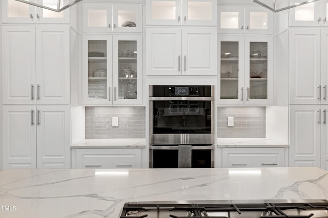 225 Midenhall Way, Cary, NC 27513 - kitchen with double oven, white cabinetry, decorative backsplash, and light stone countertops