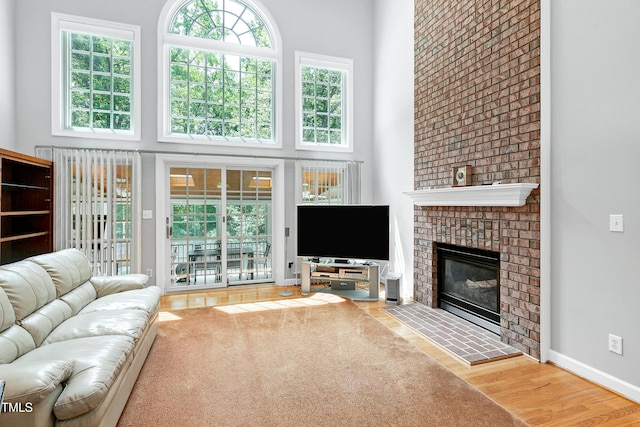 225 Midenhall Way, Cary, NC 27513 - living area featuring a high ceiling, a fireplace, wood finished floors, and baseboards
