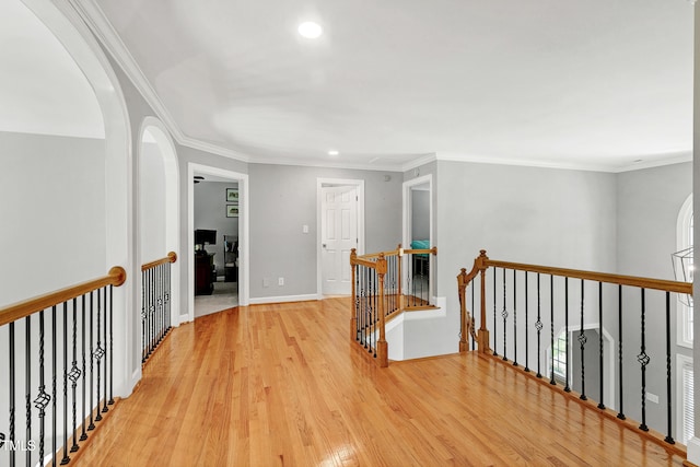 225 Midenhall Way, Cary, NC 27513 - hallway with an upstairs landing, light wood finished floors, recessed lighting, arched walkways, and ornamental molding
