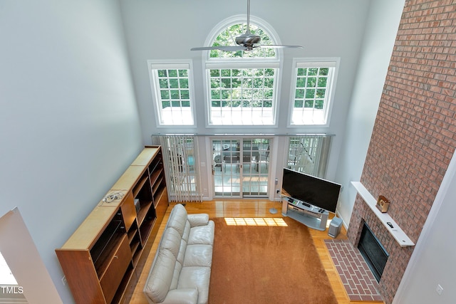 225 Midenhall Way, Cary, NC 27513 - living area featuring a towering ceiling, ceiling fan, a brick fireplace, and wood finished floors