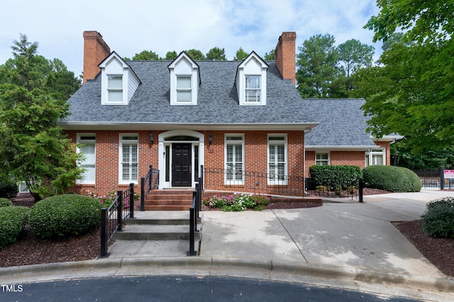 225 Midenhall Way, Cary, NC 27513 - new england style home featuring a chimney, brick siding, and roof with shingles