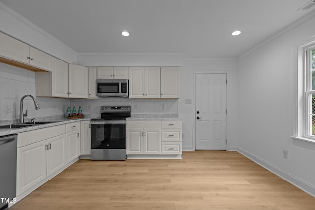 1204 Pecan Pl, Durham, NC 27704 - kitchen featuring appliances with stainless steel finishes, a sink, tasteful backsplash, healthy amount of natural light, and crown molding
