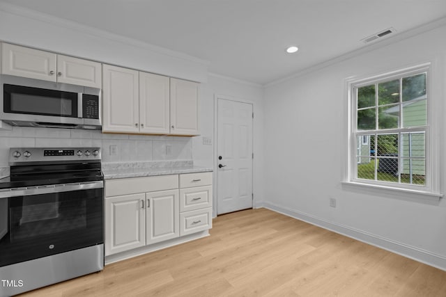 1204 Pecan Pl, Durham, NC 27704 - kitchen with stainless steel appliances, light wood finished floors, crown molding, light countertops, and decorative backsplash
