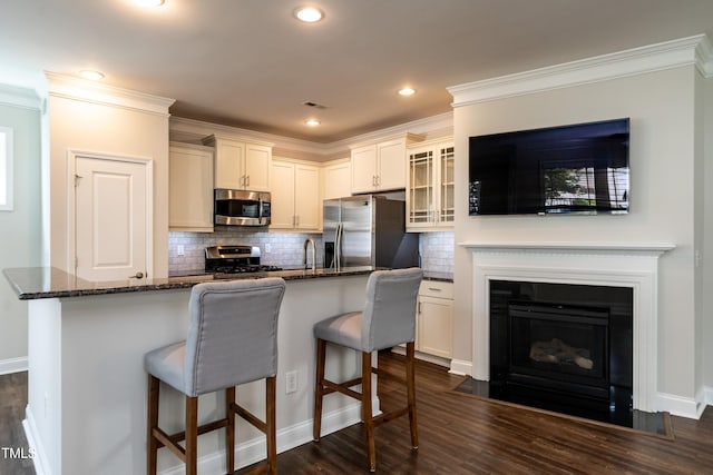 5638 Wade Park Blvd, Raleigh, NC 27607 - kitchen with stainless steel appliances, glass insert cabinets, dark wood-style floors, dark stone countertops, and backsplash