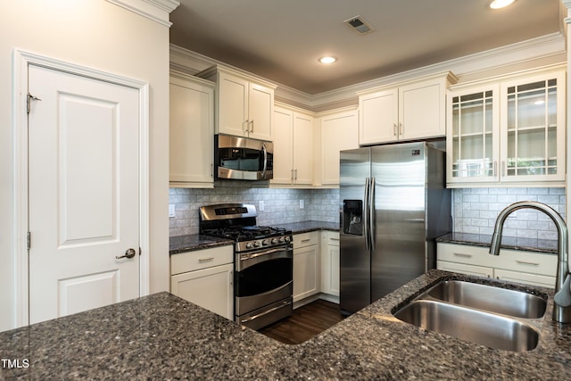 5638 Wade Park Blvd, Raleigh, NC 27607 - kitchen with stainless steel appliances, a sink, dark stone counters, glass insert cabinets, and tasteful backsplash