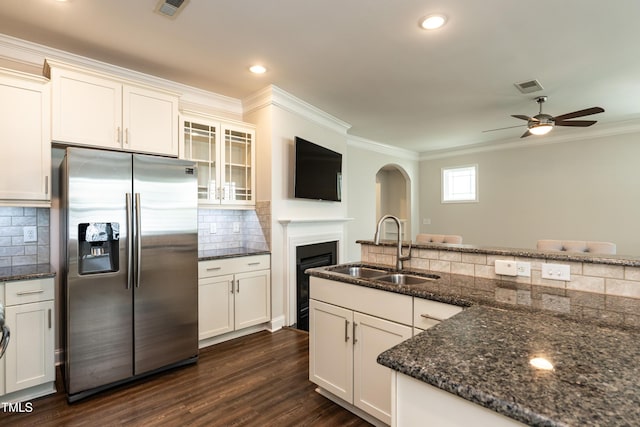 5638 Wade Park Blvd, Raleigh, NC 27607 - kitchen with stainless steel fridge, a sink, crown molding, decorative backsplash, and dark stone counters