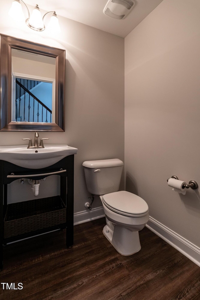 5638 Wade Park Blvd, Raleigh, NC 27607 - bathroom featuring baseboards, toilet, wood finished floors, and vanity