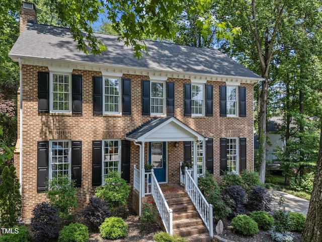 2901 Ceremonial Ct, Raleigh, NC 27615 - colonial inspired home with a chimney, brick siding, and a shingled roof