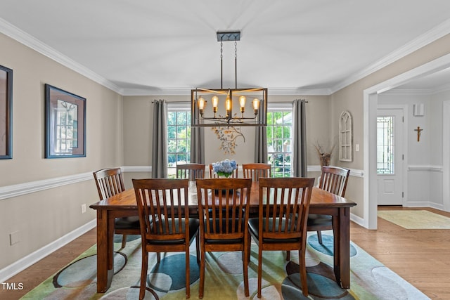 2901 Ceremonial Ct, Raleigh, NC 27615 - dining space featuring a chandelier, wood finished floors, crown molding, and baseboards